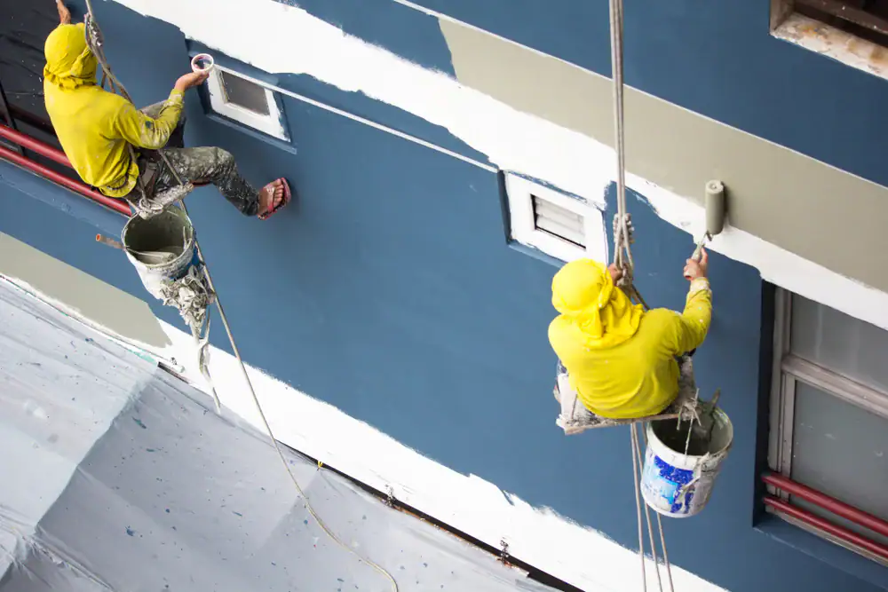 Painters from Legends Painting professionally painting a commercial building exterior in Oakland County, Michigan with precision and high-quality finishes