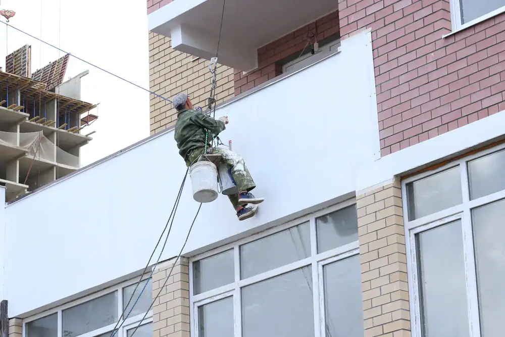 Professional exterior painting by Legends Painting team member in Oakland County, Michigan, enhancing building appearance